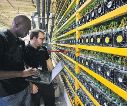  ?? AFP / LARS HAGBERG ?? Dos tècnics estudien l’extracció de bitcoins en l’empresa Bitfarms, al Quebec.