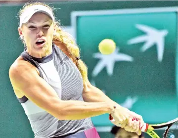  ?? — AFP photo ?? Caroline Wozniacki of Denmark hits a return against Karolina Pliskova of Czech Republic during the WTA Finals tennis tournament in Singapore on October 28, 2017.