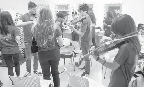  ?? JIM RASSOL/STAFF PHOTOGRAPH­ER ?? The Stoneman Douglas Orchestra warms up before the memorial concert for Carmen Schentrup. She played violin in the orchestra for three years.