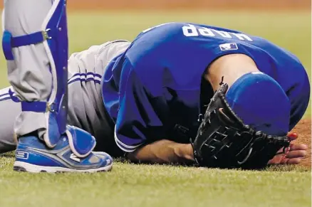  ?? Mike Carlson/the Associated Press ?? Toronto starting pitcher J.A. Happ crumpled after being hit in the head by a line drive by Tampa Bay’s Desmond Jennings on Tuesday.