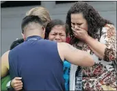  ?? — GETTY IMAGES ?? Friends and family members of Junior Seau console each other outside the former linebacker’s home.