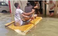  ?? — SUPPLIED PHOTO ?? People use makeshift boats to travel through flooded streets in Sharjah to buy groceries and for other work.