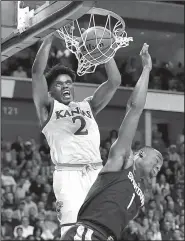  ?? AP/TONY GUTIERREZ ?? Kansas guard Lagerald Vick (left) dunks over Michigan State defender Joshua Langford during their second-round game last week. The Jayhawks have won their first two tournament games by an average of 29 points but might have a tough time with Purdue...