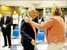  ??  ?? La doyenne des élus remettant l’écharpe au maire après son élection.