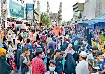  ?? — S. SURENDER REDDY ?? People shop for Id-ul-Fitr before the lockdown kicks in at 10 am on Wednesday. It was unusual to see shoppers early in the morning in Charminar.