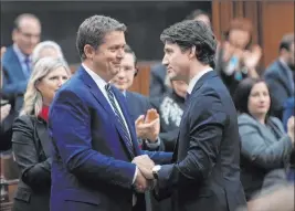  ?? Adrian Wyld The Associated Press ?? Canadian Prime Minister Justin Trudeau, right, shakes hands with Andrew Scheer on Thursday in the House of Commons in Ottawa. Scheer said he will step down as leader of the opposition Conservati­ve Party in response to poor election results.