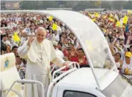  ?? THE ASSOCIATED PRESS ?? Pope Francis waves from Popemobile as Myanmar Catholics wave flags ahead of the holy Mass Wednesday in Yangon, Myanmar.