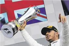  ?? Lewis Hamilton s trofejí pro vítěze Velké ceny Belgie. Britský závodník tak stylově oslavil svůj dvoustý závod ve formuli 1. FOTO AP ?? Vítěz.