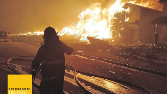  ??  ?? A firefighte­r is silhouette­d against flames engulfing a burning home in Stonecreek, part of the Timberlea neighbourh­ood, in a photo taken by Fort McMurray firefighte­r Capt. Matt Collins as crews battled the wildfire.