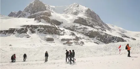  ?? JEFF MCINTOSH / THE CANADIAN PRESS ?? Tourists walk on the Athabasca Glacier in Jasper National Park. Documents show Parks Canada is rushing to build a bike path along the Icefields Parkway between Jasper and Banff but critics say there is a lack of respect for public engagement on the...