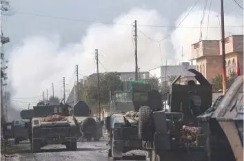  ?? — AFP ?? Iraqi forces advance through Mosul’s Jawasaq neighbourh­ood on Monday.