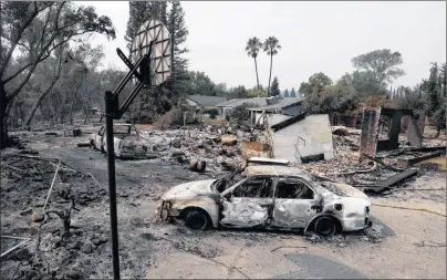  ?? AP PHOTO ?? Burned vehicles sit in front of a wildfire-ravaged home, Sunday in Redding, Calif.