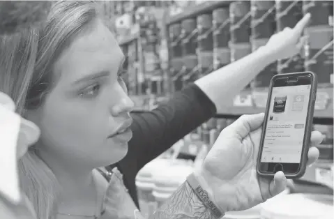  ?? MICHAEL KOFSKY FOR USA TODAY ?? At a Home Depot in Marina del Rey, Calif., employee Brandi Flores uses the company’s mobile app to assist a customer Monday.