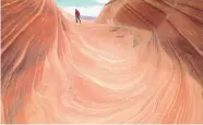  ?? BRIAN WITTE/ASSOCIATED PRESS ?? A hiker walks through a rock formation known as The Wave in the Paria Canyon-Vermilion Cliffs Wilderness area. Access is limited to 20 people a day.