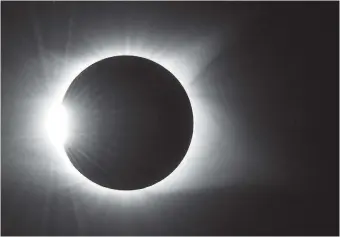  ?? STAFF PHOTO BY DOUG STRICKLAND ?? Shot from Spring City, Tenn., the sun barely peeks out from behind the moon on Monday as the eclipse nears totality.