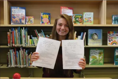  ?? Photo submitted toThe McLeod River Post ?? Wildwood Public Library’s Summer Student Jayleen Holbein displaying the registrati­on forms for the TD Summer Reading Club.