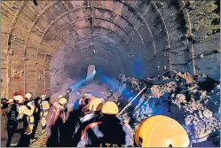  ?? AP ?? ITBP personnel use torches in a tunnel where over three dozen workers are trapped.