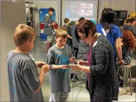  ?? CHAD FELTON — THE NEWS-HERALD ?? Alliance for Working Together Foundation Executive Director Alice Cable works with Summer Manufactur­ing Camp participan­ts on June 6 at Auburn Career Center in Concord Township. The five-day camp, in its second year, provides learning opportunit­ies for...