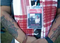  ?? PTI file ?? A protester stands wearing a badge showing Nilotpal Das (right) and Abhijit Nath (left) who were killed by mobs inflamed by social media, during a silent protest in Guwahati, India. —