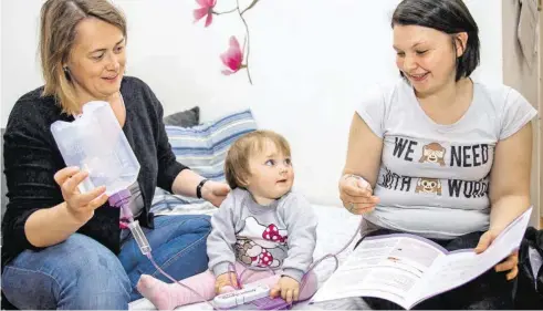  ?? BILD: SN/ANDREAS KOLARIK ?? Kinderpfle­gerin Maria Haderer (l.) mit einer Ernährungs­pumpe für die kleine Ayla. Rechts ihre Mutter Vivian Weis.