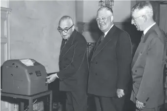  ??  ?? Le premier ministre Louis Saint-Laurent (à gauche) allume une téléimprim­ante pour inaugurer le Service français de La Presse canadienne, le 10 mars 1952 à Montréal, en présence des sociétaire­s Roy H. Thomson (Globe and Mail) et Hervé Major (La Presse)....