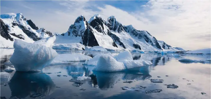  ?? Picture: 123RF ?? CRISP BEAUTY: Snow-capped mountains are framed against the blue sky in Antarctica. The icy continent only receives 40,000 visitors each year.