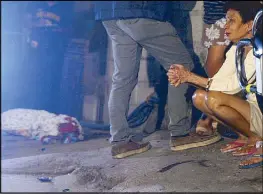  ?? JOVEN CAGANDE ?? The mother of Cristeta Ramos looks at the body of her daughter, who was killed by unidentifi­ed assailants in Barangay Batasan Hills, Quezon City at past midnight yesterday.