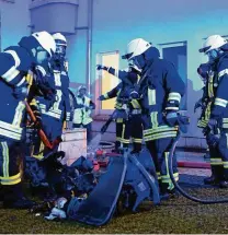  ??  ?? Feuerwehrl­eute löschen die Überreste zweier Müllcontai­nern, die in Jena in einem verschloss­enen Raum gebrannt hatten. FOTO: T. ZIPPEL