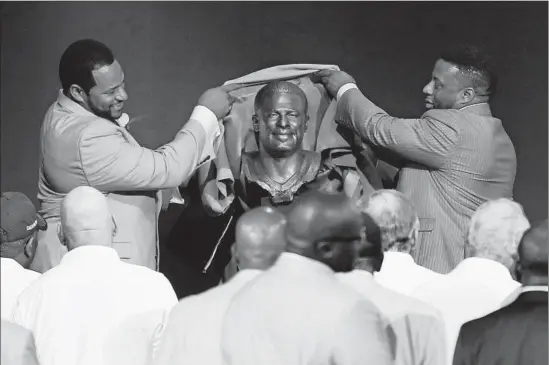  ?? Tom E. Puskar Associated Press ?? JEROME BETTIS, left, unveils his Hall of Fame bust with the help of his brother John. Bettis, who began his NFL career in L.A., is sixth all-time in rushing yards.