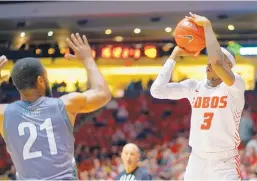  ?? ADOLPHE PIERRE-LOUIS/JOURNAL ?? UNM’s Keith McGee (3) shoots over ENMU’s Ibn Zaid during the Lobos’ 92-71 win over the Greyhounds Wednesday.