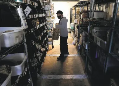  ?? Photos by Carlos Avila Gonzalez / The Chronicle ?? Associate Jose Yeh fills a customer's order at the Farmstead online grocery warehouse in Burlingame.