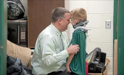  ??  ?? Pine-Richland basketball coach Jeff Ackermann embraces his son, Bryson, before the Pine-Richland versus North Hills game Jan. 11. It was Bryson’s first outing from The Children’s Home of Pittsburgh, where he was recovering from acute flaccid myelitis.