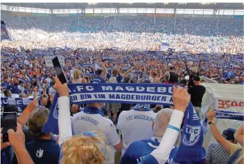  ?? FOTO: FÖRSTER/DPA ?? Die Magdeburge­r Fans feiern nach dem 2:0-Erfolg im Heimspiel gegen Fortuna Köln den Aufstieg in die 2. Fußball-Bundesliga. Für den Osten ist das ein Glücksfall in turbulente­n Zeiten.