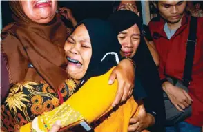  ??  ?? A widow, whose husband was killed in a massacre by suspected separatist rebels, grieves following the arrival of her late husband’s casket in Makassar, South Sulawesi, yesterday.