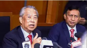  ??  ?? Fielding the media: Muhyiddin (left) speaking at a press conference in Putrajaya as AADK director general Datuk Seri Zulkifli Abdullah looks on.