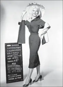  ?? Photograph­s by 20th Century Fox Film ?? JAYNE MANSFIELD strikes a pose next to a production placard during filming of 1957’ s “Will Success Spoil Rock Hunter?”