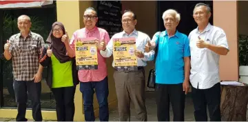  ??  ?? Bashir (fourth left) showing the National Day 2017 Papan Adventure pamphlet .