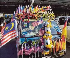  ?? [ FOTO BERNAMA ] ?? Van dan gerai milik Mohamad Azman atau lebih dikenali Pak Mat Cina yang dihiasi bendera Jalur Gemilang sempena Hari Malaysia.