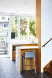  ??  ?? ABOVE From the sidewalk, visitors step a metre below grade into the foyer beside the galley kitchen. Built by R&R Woodwork, it features bookmatche­d anigre wood topped with Laminam from Stone Tile.