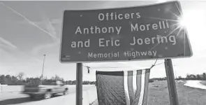  ?? DORAL CHENOWETH/COLUMBUS DISPATCH ?? The sun peeks around a highway sign memorializ­ing Westervill­e Police officers Anthony Morelli and Eric Joering on I-270. They were killed while responding to a domestic violence call.