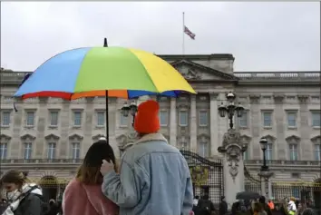  ?? Alberto Pezzali/Associated Press ?? A couple pay tribute to Prince Philip on Saturday at Buckingham Palace in London.