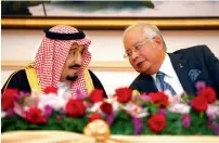  ?? — Reuters ?? King Salman bin Abdulaziz speaks with Najib Razak during a ceremony to sign agreements in Malaysia on Monday.