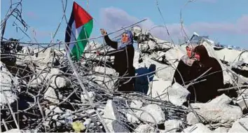  ?? Reuters ?? Palestinia­n women gather at the site of their demolished home earlier this year. The internatio­nal community has been criticised for not holding Israel accountabl­e for its actions.