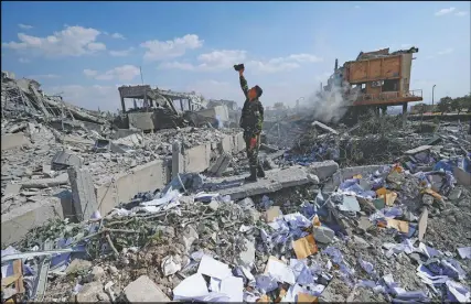  ?? AP PHOTO ?? A Syrian soldier films the damage of the Syrian Scientific Research Center in Barzeh, near Damascus, Syria, which was attacked by U.S., British and French military strikes to punish President Bashar Assad for suspected chemical attack against civilians.