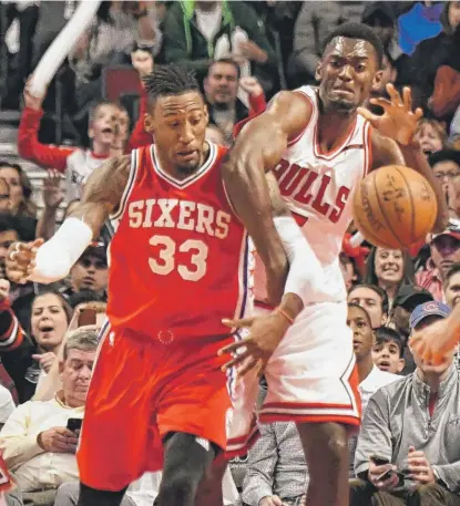  ?? | AP ?? Bulls forward Bobby Portis and Sixers forward Robert Covington go for the ball in the second half Friday at the United Center.