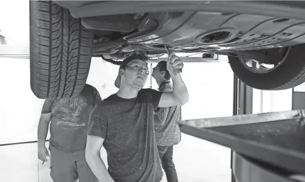  ??  ?? Brayden Leonard checks a tire during during the auto tech class on August 24. Leonard, who at 17 is among the youngest in the class, said he was eager to learn additional skills that will help him get a job.