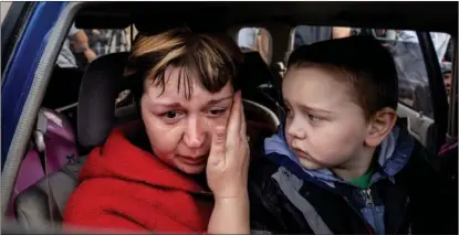  ?? EVGENIY MALOLETKA / AP ?? A Ukrainian woman cries as her grandson looks on in a car at a center for displaced people in Zaporizhzh­ia on May 2.