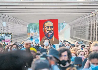  ?? ?? Marchers cross the Brooklyn Bridge in May 2021, demanding police reform after a ceremony to honour the one-year anniversar­y of George Floyd's death. This year, U.S. President Joe Biden is to appear alongside relatives of Floyd, whose killing by Minneapoli­s police sparked nationwide protests.