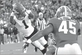  ?? HYOSUB SHIN / AJC, AP ?? Georgia Tech’s Qua Searcy (1) dives to stretch the ball over the goal line for the game-winning touchdown against Georgia on Saturday in Athens.