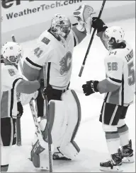  ?? Associated Press photo ?? Calgary Flames goalie Mike Smith celebrates with Ryan Lomberg, right, and Mark Giordano after the Calgary Flames defeated the Chicago Blackhawks 3-2 in an NHL game Sunday in Chicago.